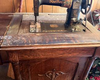 Antique New Home treadle sewing machine, oak cabinet