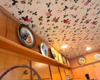 Decorative wall plates and collectibles on display shelf