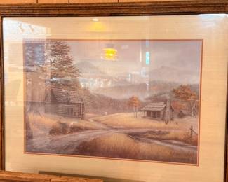 Framed autumn landscape painting with cabin