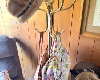 Brass coat rack with vintage hats and handbags