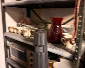 Metal shelving with dishes, plates, and household items
