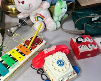 Retro Fisher-Price & Care Bears – Iconic 1980s toys including a Cheer Bear (rainbow) plush, Fisher-Price "Chatter" pull telephone, and a vintage "Pull-A-Tune" xylophone