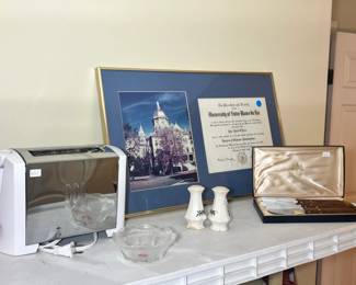 A framed University of Notre Dame diploma, a modern chrome toaster, ceramic salt and pepper shakers, and a boxed steak knife set