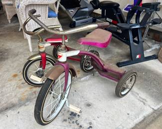 "Junior" brand metal tricycles with classic swept-back handlebars and original patina