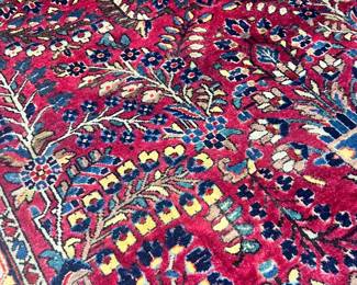 A beautiful hand-knotted wool area rug featuring a vibrant red field with intricate floral "Tree of Life" and medallion patterns