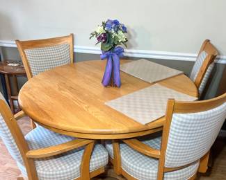 Oak Dining Suite: Round oak table with four swivel-base chairs on casters