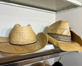 A pair of classic woven straw cowboy hats, one featuring a decorative patterned band