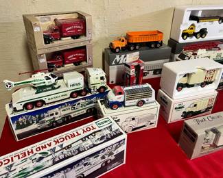 Hess & First Gear Collectibles – A spread of Hess Toy Trucks (including the Helicopter and Gasoline tankers) alongside First Gear "Thrift Market" and GMC insulated van replicas in original packaging.