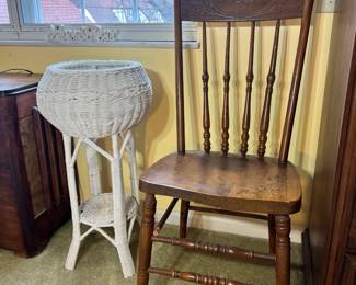 Side chair with spindle details and a white woven wicker planter