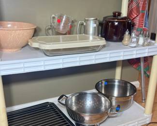 Vintage pink speckled melamine mixing bowl, Pyrex baking dishes with lids, stainless steel colanders, and vintage glass salt and pepper shakers