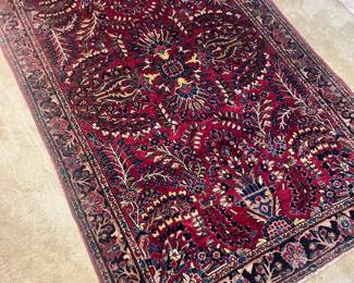 A beautiful hand-knotted wool area rug featuring a vibrant red field with intricate floral "Tree of Life" and medallion patterns