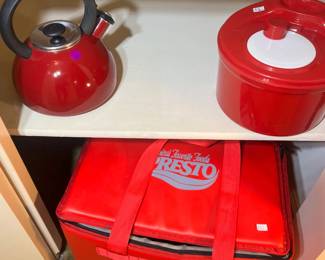 A red enamel tea kettle and a Presto insulated food carrier