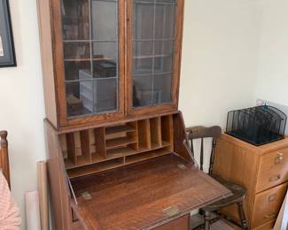 #126	Wood Secretary w/2 leaded glass doors w/2 shelves & 3 drawers w/flip-front and cubbies - 28x15-27x72" tall (as is side crack and trim on bottom)	 $100.00 