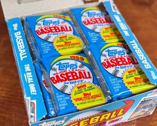 This lot features a collectible box of sealed 1989 Topps Major League Baseball trading card packs. The box contains many packs, each featuring 15 baseball cards and one stick of bubble gum. These packs were part of a “Spring Fever Baseball” promotion offering a chance to win a trip to 1990 Spring Training.
