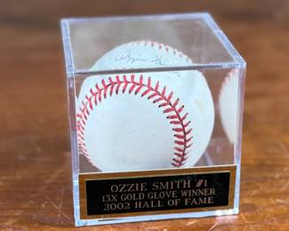 This lot features a signed baseball by 13x Gold Glove winner and 2002 Hall of Famer, Ozzie Smith. Comes in a display case.