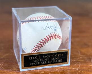 This lot features a signed baseball by Reggie Jackson, 1993 Hall of Famer with 563 home runs. Comes in a display case.