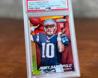 This lot features a 2014 Panini Prizm Silver Prizm #243 Jimmy Garoppolo Rookie Card, graded by PSA as a Near Mint 7. 