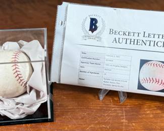 This lot features a baseball with twenty-six (26) autographs from the 1965 Los Angeles Dodgers. Notable signatures include Walter Alston, Don Drysdale, and Sandy Koufax. Accompanied in a display case with authentication papers from Beckett.