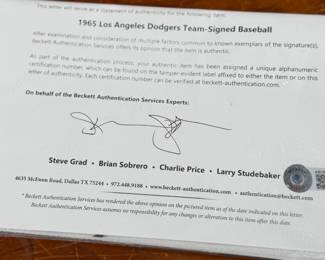 This lot features a baseball with twenty-six (26) autographs from the 1965 Los Angeles Dodgers. Notable signatures include Walter Alston, Don Drysdale, and Sandy Koufax. Accompanied in a display case with authentication papers from Beckett.