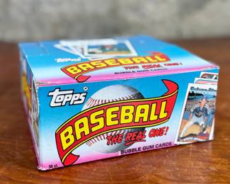 This lot features a collectible box of sealed 1989 Topps Major League Baseball trading card packs. The box contains many packs, each featuring 15 baseball cards and one stick of bubble gum. These packs were part of a “Spring Fever Baseball” promotion offering a chance to win a trip to 1990 Spring Training.