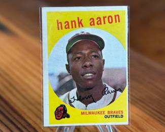 This lot features a 1959 Topps #380 Hank Aaron baseball card. It is a collectible item featuring the Hall of Famer in his Milwaukee Braves uniform.