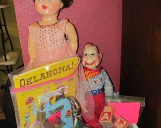 dolls including an original HOWDY DOODY doll from the 1950s. an antique metal childs sewing machine and iron and a 1957 paper doll book based on the musical "OKLAHOMA"