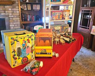 a table of Barbie and Ken plus accessories, clothing and another table with cars