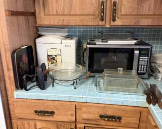 bread maker, microwave, vintage Pyrex bakeware,  and vintage irons