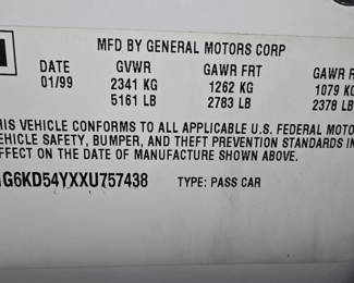 1999 Cadillac DeVille featuring a white exterior, chrome wheels, and a black landau top