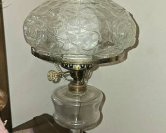 vintage clear pressed glass oil lamp resembles the "Princess Feather" pattern, a popular design from the late Victorian era. 