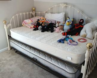 White metal trundle bed with mattress, stuffed animals