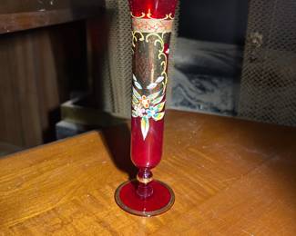 A vintage red Bohemian glass vase with hand-painted floral and gold decoration.