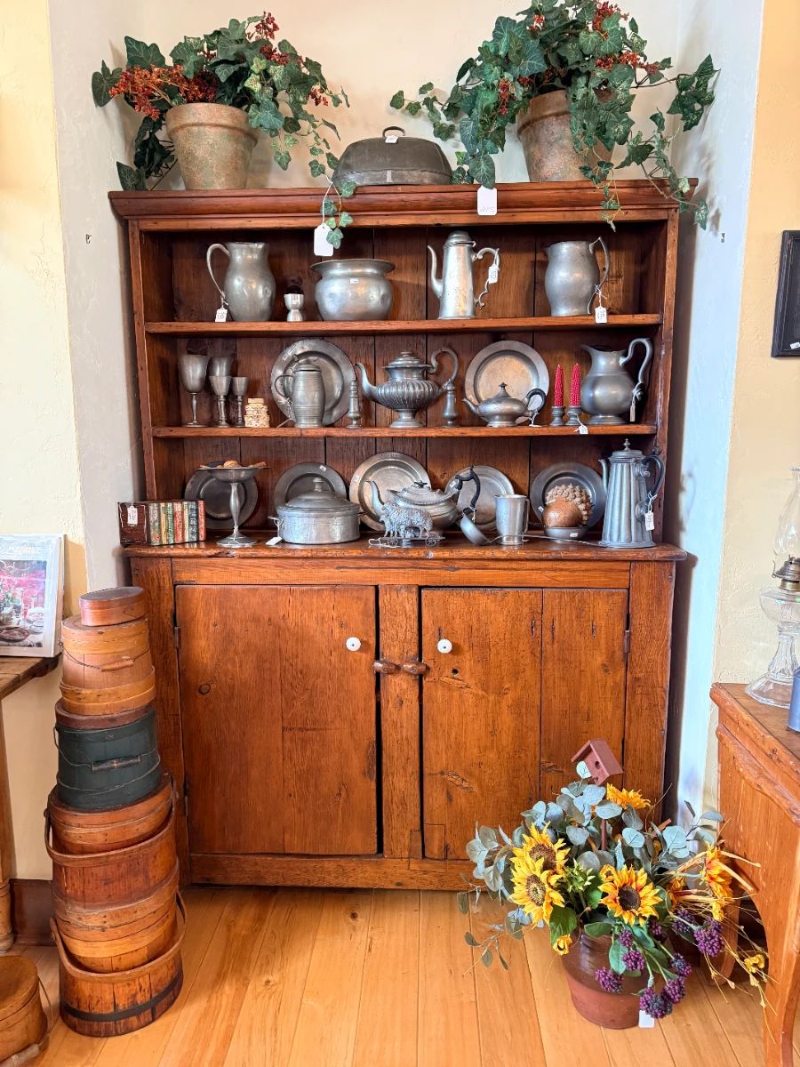 Country pine cabinet filled with antique pewter