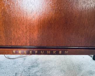 Stunning 1960s Mid-Century Modern West German stereo console cabinet by Telefunken. Features gorgeous wood-slat vertical speaker grilles, clean Scandinavian design lines, and iconic tapered legs. The wooden cabinet body is in exceptional vintage condition with beautiful grain patterns and minimal wear. The top lids lift up to access the integrated vintage stereo receiver, and the center features a classic drop-down media storage bay. The original turntable is intact but currently non-functional—making this a perfect aesthetic credenza, a Bluetooth conversion project, or a restoration piece for vintage audio enthusiasts!