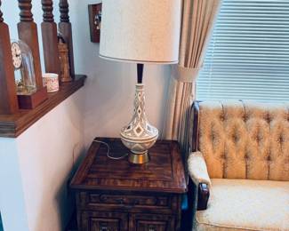 Gorgeous Mid-Century Modern living room furniture: MCM Textured Ceramic Table Lamp: Large statement lighting piece featuring a beautifully sculpted, cream-toned ceramic body with mid-century geometric textures, polished brass/gold metal accents, and its original large fabric drum shade. In excellent vintage condition and fully operational. (shade has slight discoloration in three places) Also, MCM Walnut Nightstand / End Table: Solid wood side table featuring iconic clean mid-century modern lines, a spacious storage drawer with its original metal hardware, and a lower open shelf perfect for books or display. Rich wood grain finish with minimal vintage wear.