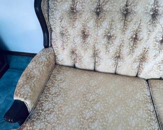 Stunning vintage Hollywood Regency / Mid-Century Modern tufted sofa. Features an elegant curved silhouette upholstered in a rich, shimmering gold satin fabric. Fully designed with deep button tufting across the backrest, a comfortable three-cushion seat configuration. Supported by a beautifully carved dark wood accent trim along the front armrests and bottom edge. A high-end vintage statement seating piece in exceptional condition, perfect for adding classic retro luxury to any living space.