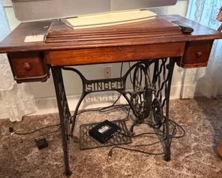 Singer Singer Logo Treadle Sewing Machine with Ornate Cast Iron Base and Wooden Cabinet