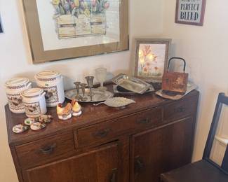 wood buffet or sideboard, dining chais, large framed floral matted art, white ceramic canisters, silver plate serving pieces