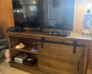 console table with barn type door, television, lamp