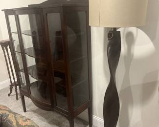 Curved glass curio cabinet hutch, wooden floor lamp, oak plant stand.