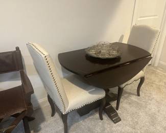 Fold down wooden table with two upholstered studded dining room high back chairs. 