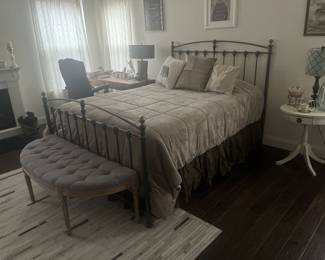Wrought iron bed frame, cresent shaped upholstered bench. Small vintage round end table. 