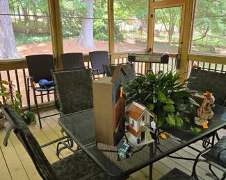 Outdoor wrought iron table (with center umbrella hole) and 6 coil spring dining chairs. Includes cushions. 3 hightop folding chairs in background. All in great condition.  A porch swing, outdoor heater, bird houses, shepherd hooks, plants, and porch/outdoor items & decor. 