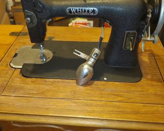 White metal casing sturdy sewing machine with it's cabinet