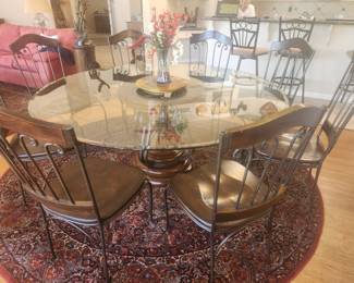Round glass toped 76 inch table with eight iron and wood chairs