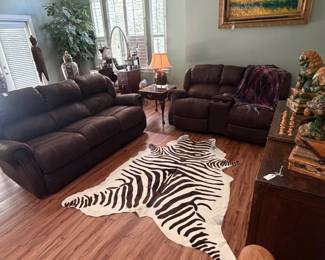 Cowhide rug painted with zebra strips and newly cleaned couch and loveseat 