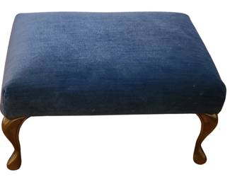 A vintage blue upholstered ottoman with a rectangular cushioned top and four curved wooden legs in a polished finish. The dark blue fabric gives it a classic, versatile look, and the gently curved legs add an elegant, traditional touch. It works well as a footstool, small accent seat, or decorative piece in a living room or bedroom.  Priced at $50