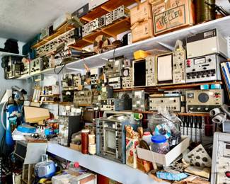 A whole bay full of electronic oscilloscopes, meters, voltage readers, ham radios, circuit boards, electronics.