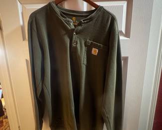 Olive green long-sleeve Carhartt work shirt with chest pocket and logo patch.