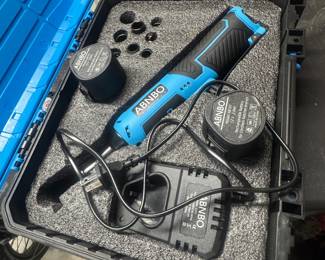Portable power tool kit with blue electric tool, cords, and accessories in a foam-lined carrying case.